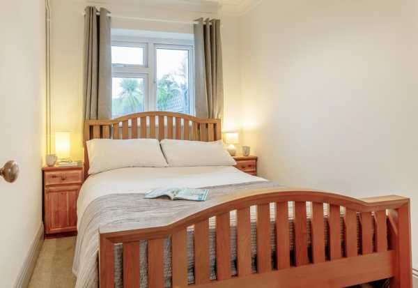 The Cottage - comfortable bedroom with wooden furniture