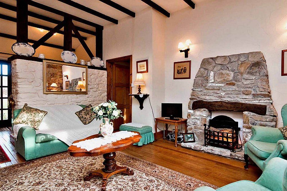 Luxury cottage living room with stone fireplace and exposed beams