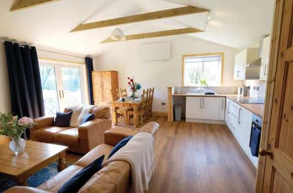 The Pendragon - open-plan living area with exposed wooden beams and modern kitchen